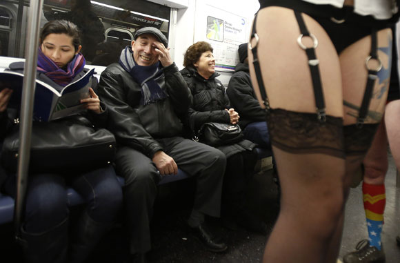People watch as participants in the No Pants Subway Ride take the 6 train downtown in New York January 13, 2013