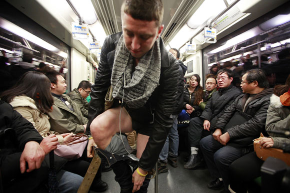 Passengers react to seeing a man take off his pants on the subway during the annual No Pants Subway Ride in Shanghai January 13, 2013