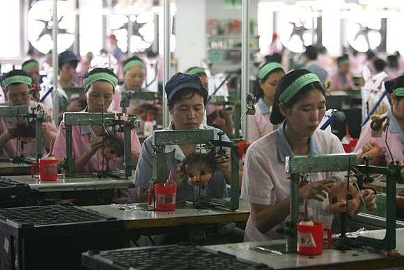 Workers assemble dolls at the production line of Jetta (China) Industries Co., Ltd.