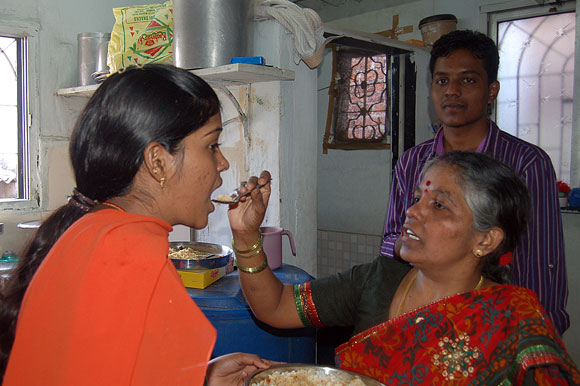 Prema Jayakumar's mother Lingammal feeds her as her brother Dhanraj savours the moment.