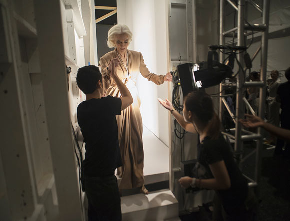 Model Carmen Dell'Orefice (C) is helped off the runway backstage after participating in the runway show for fashion designer Norisol Ferrari's Spring/Summer 2013 collection during New York Fashion Week September 10, 2012. The collection is Ferrari's first runway show.