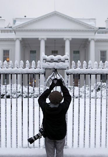 A photojournalist takes pictures of the White House in Washington, DC