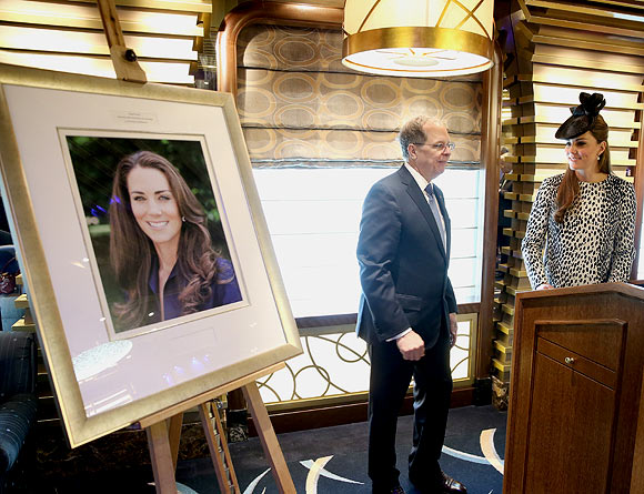 President and CEO of Princess Cruises Alan Buckelew escorts Catherine, Duchess of Cambridge as she looks at an image of herself during a tour of the Princess Cruises ship after its naming ceremony at Ocean Terminal on June 13, 2013 in Southampton, England