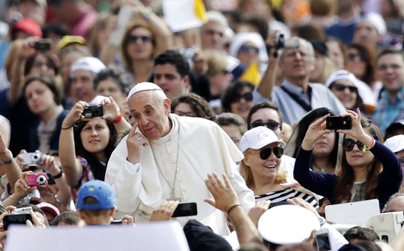 Pope Francis gestures as he arrives to lead his Wednesday general audience in Saint Peter's Square at the Vatican June 5, 2013.