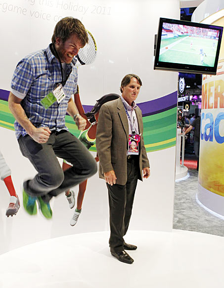 A Microsoft employee jumps as he and an attendee play Kinect Sports Season Two at the Microsoft XBOX 360 booth at E3 in Los Angeles, California.