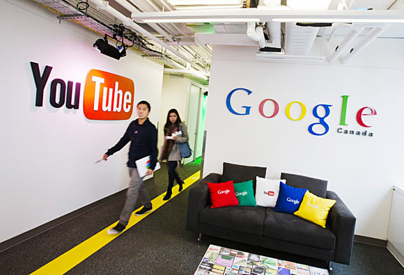 People walk by a YouTube sign at the new Google office in Toronto.