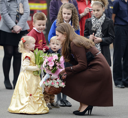 Britain's Catherine, Duchess of Cambridge receives flowers from children during a visit to Peak Lane fire station in Grimsby, northern England March 5, 2013.