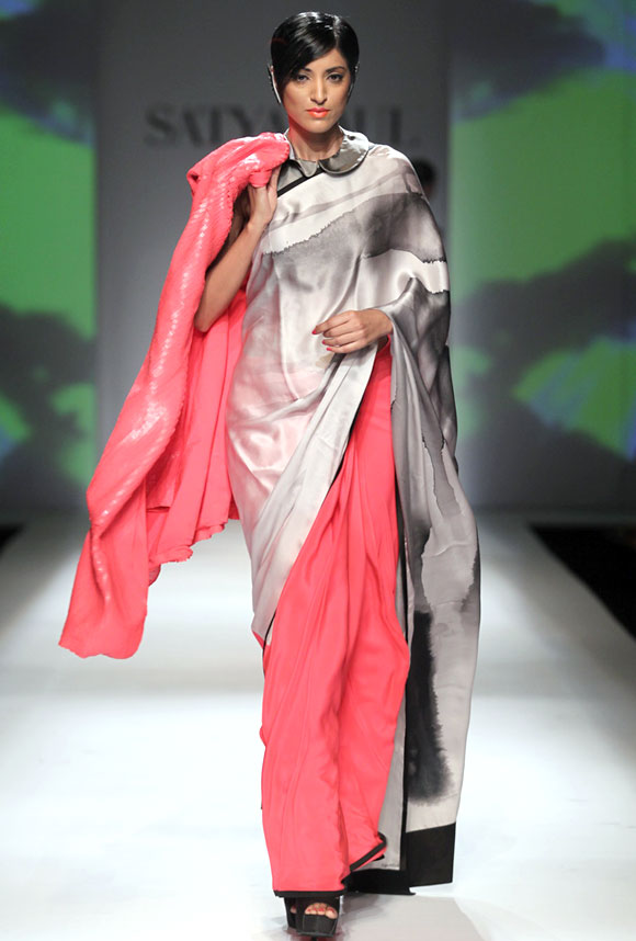 Jesse Randhawa shows a pink, white and grey saree, with a collared blouse and a long embellished jacket.
