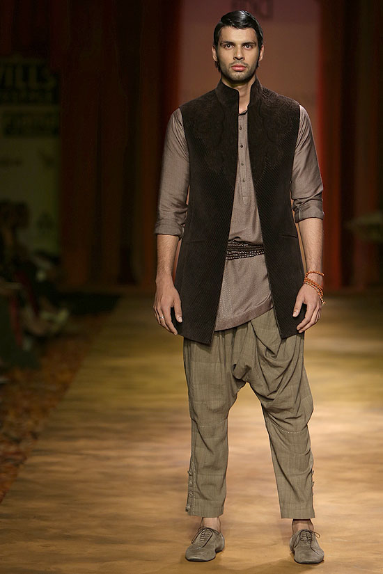 A model sports a dhoti pant with a kurta and a jacket for Tarun Tahiliani.