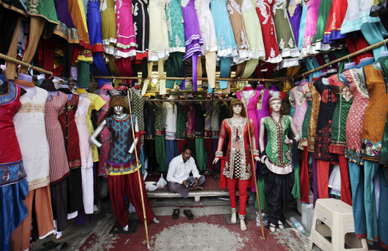 A vendor waits for customers at his shop selling clothes, at a market in Mumbai January 31, 2012. India's economy is expected to grow faster in the next fiscal year than the pace it is expected to expand in the current year, Kaushik Basu, the chief economic adviser to the finance ministry, said on Tuesday.