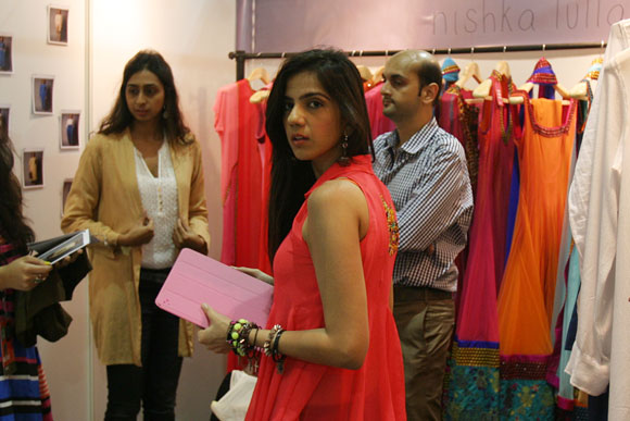 Fashion designer Nishka Lulla inside her stall speaking with interacting buyers