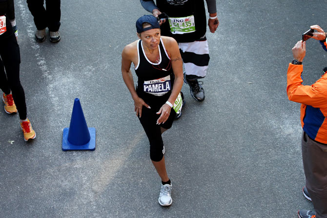Pamela Anderson crosses the finish line in Central Park during the 2013 ING New York City Marathon in New York City.