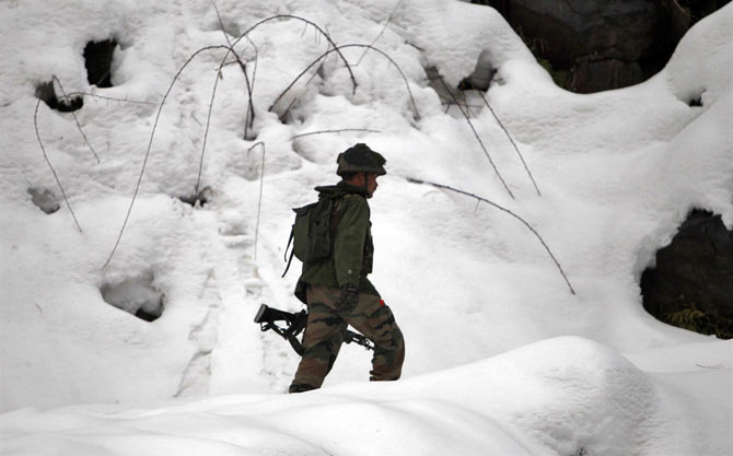 An Indian army soldier patrols near the Line of Control in Churunda village, about 129 km (80 miles) northwest of Srinagar