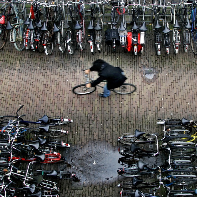 A man rides his bike in a bicycle shed near Central Station Amsterdam. There are more bicycles than people in the Netherlands, where each resident clocks up an average of 917 km (573 miles) a year on two wheels.