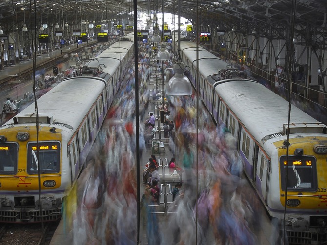 Commuters disembark from crowded suburban trains during the morning rush hour at Churchgate railway station on World Population Day in Mumbai.