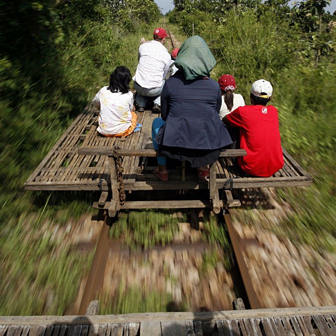 Cambodians ride a bamboo train, known locally as a norry, at new village train station in Pusat province 200 km northwest of Phnom Penh.