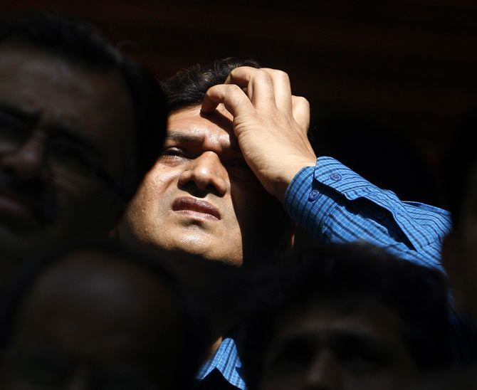A man looks at a large screen displaying India's benchmark share index on the facade of the Bombay Stock Exchange (BSE) building in Mumbai March 13, 2008. Indian shares fell nearly 5 percent by Thursday afternoon to their lowest in more than six months, led lower by index heavyweights Reliance Industries Ltd. 