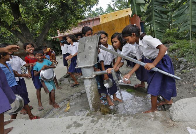 Schoolchildren wash their plates before having their mid-day meal at a primary school in Brahimpur village, Chhapra, Bihar, July 19, 2013.
