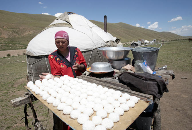 A woman forms balls of salted cow cheese to dry in the sun in the Susamyr Valley near the Bishkek-Osh highway, some 200 km from Bishkek. The Bishkek-Osh highway is part of the historic Silk Road, an ancient trade route running through various regions of the Asian continent into China.