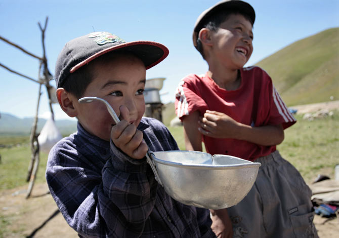 A boy drinks from a ladle in the Susamyr Valley near the Bishkek-Osh highway.