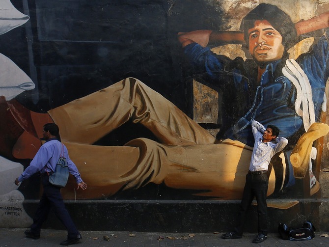 Ram Pratap Verma, a 32-year-old aspiring Bollywood film actor, poses in front of a mural of actor Amitabh Bachchan in Mumbai May 1, 2013. Bollywood is an addiction for many; an addiction that attracts thousands of aspiring stars to the city of Mumbai. Ram Pratap Verma made the journey from his small village eight years ago, and despite carrying his whole 'home' inside his bag, he is determined not to give up on his ambitions.