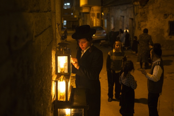 An Ultra-Orthodox Jewish man lights candles for the holiday of Hanukkah in Jerusalem's Mea Shearim neighbourhood.