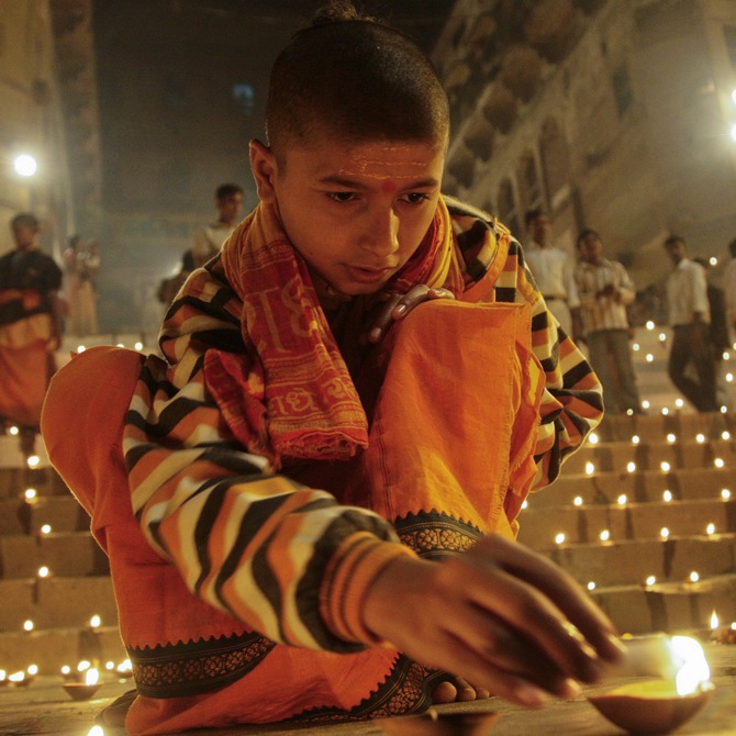 A Hindu devotee lights an earthen lamp on the steps of Sindhiya Ghat, Varanasi.
