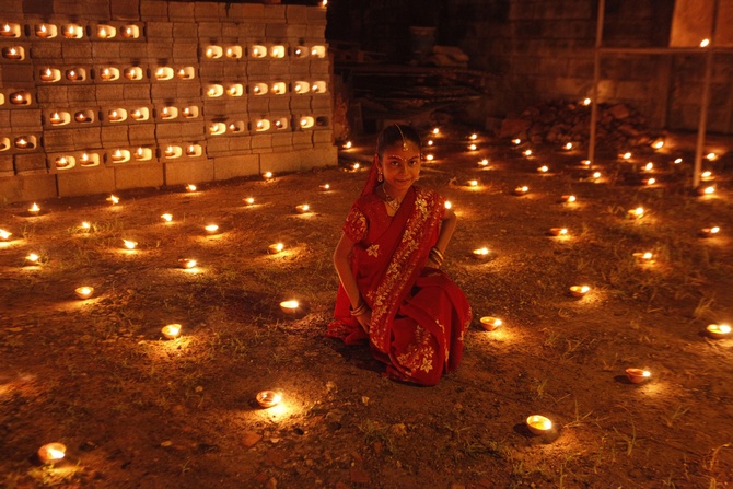 A girl sits among diyas, or oil lamps, in her yard during Diwali celebrations in Felicity, central Trinidad.