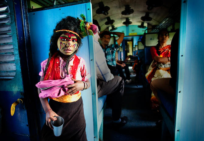 A boy dressed as Lord Shiva, begs for alms in a train compartment in West Bengal. This picture was adjudged the best in the 'People' category.