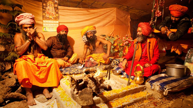Hindu saints congregate at the 2013 Kumbh Mela amidst strong opium smell and the smoke of burning wood to decide their next day's programme. 