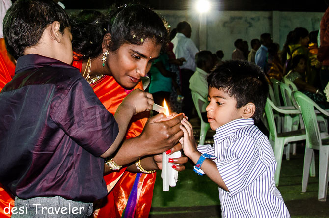 A mother helps her sons light the candles ahead of the mass.