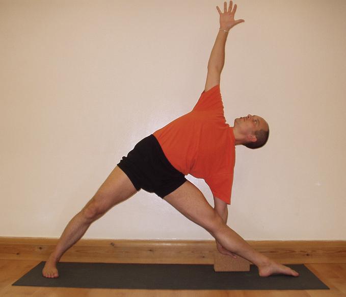 A student performing Uttitha Trikonasana, triangle pose, one of the basic standing poses in Iyengar Yoga.