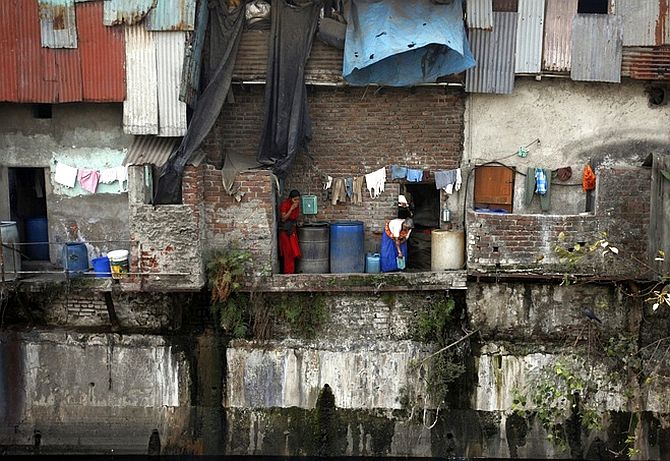 Women wash themselves outside their shanty in Dharavi.