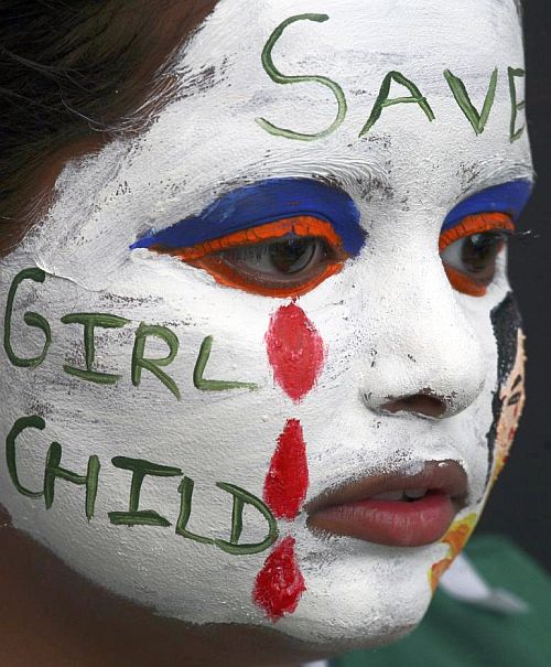 A girl with her face painted with an awareness message on female foeticide.
