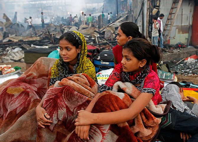 Rubina Ali ( R ), who acted as young Latika in the Oscar-winning film Slumdog Millionaire, sits with her family amid the ruins of the Gharib Nagar slum in Mumbai. A fire gutted the slum.