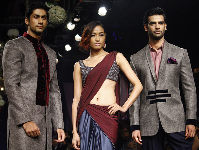 Katheleno Kenze is flanked by two hunks during Manish Malhotra's show