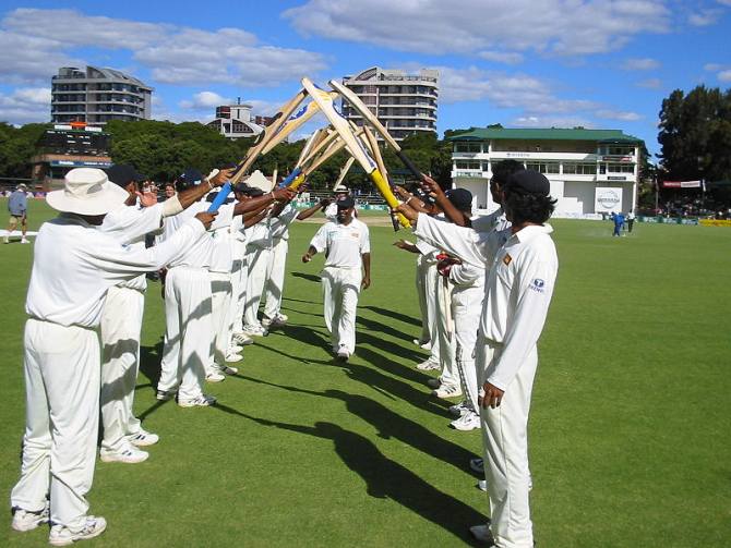 Sri Lankan players give teammate Muttiah Muralitharan a guard of honour in Harare after he broke Courtney Walsh's record for most Test wickets.
