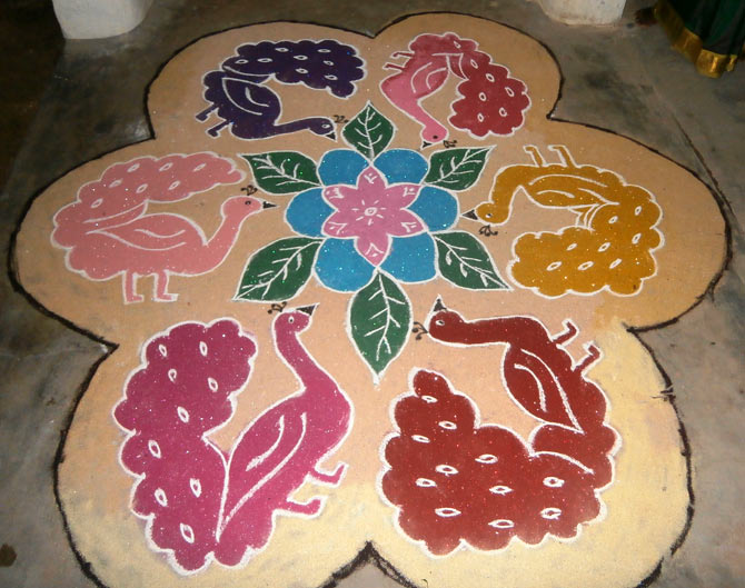 A colourful kolam is drawn in front of the home to welcome Lord Ganesha