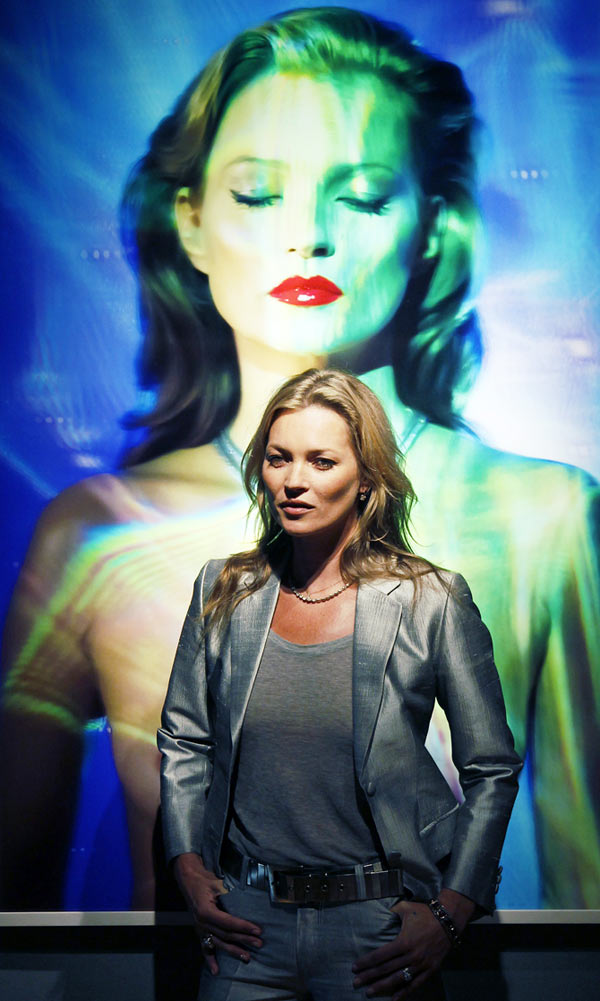 Model Kate Moss poses with She's Light (Laser 3), by photographer Chris Levine at Christie's auction house in London.