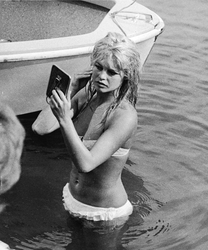 A file picture of Brigitte Bardot looking at her reflection in a mirror, while standing in the waters of Lake Leman.