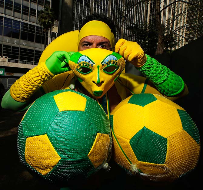 A Brazil fan puts on his costume before watching a telecast of the 2014 World Cup soccer match between Brazil and Chile, at a FIFA fan area in Sao Paulo June 28, 2014.