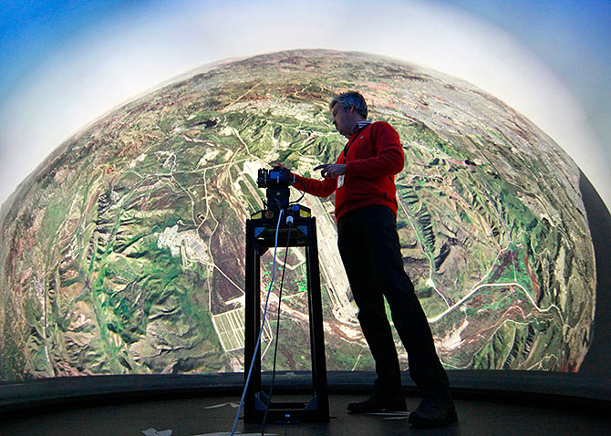 Geert Matthys, research and development manager at Barco, a Belgian company specialising in high-definition projectors and displays, gives an explanation inside a fully immersive 360-degree flight simulator in Kuurne October 11, 2011. Barco has unveiled the ultimate fighter jet training tool designed to reproduce reality exactly as a pilot sees it. The dome is the first ever flight simulator to give trainee pilots a full 360 degree view of the world as they conduct virtual missions, said Barco.