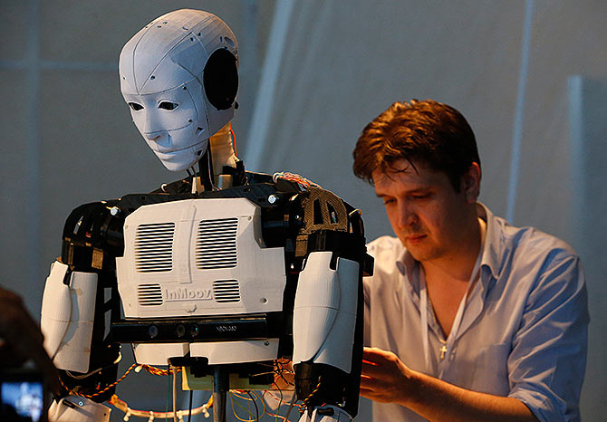 A technician makes adjustments to the 'Inmoov' robot from Russia during the 'Robot Ball' scientific exhibition in Moscow