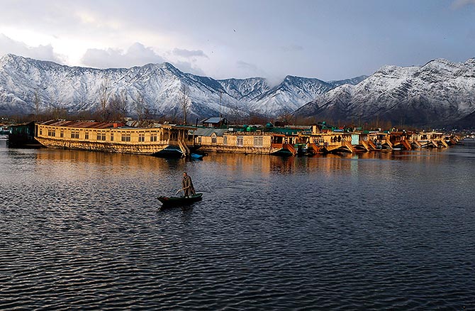 A Kashmiri man rows his boat in the waters of the Dal Lake on a cold winter evening in Srinagar