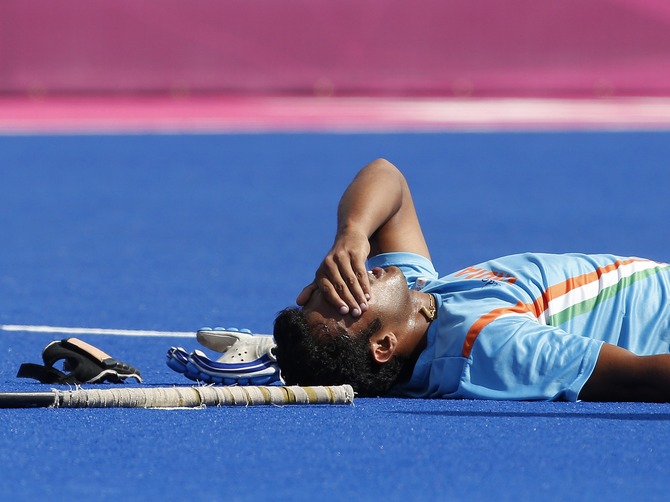 India's Raghunath Vr lies on the pitch after being injured during the men's Group B hockey match against Germany at the London 2012 Olympic Games.