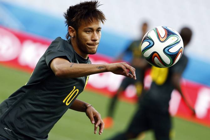 Brazil's Neymar eyes the ball during his team's final practice in Sao Paulo one day before the opening match of the soccer World Cup between Brazil and Croatia June 11, 2014