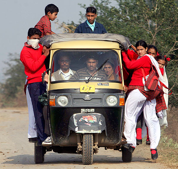 School children travel on a motorised rickshaw in Gharana village, about 30 km (19 miles) southwest of Jammu December 11, 2008.