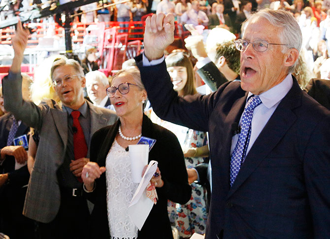 Wal-Mart Stores family members (L - R) Jim Walton, Alice Walton and Chairman of the Board of Directors Rob Walton recite the Walmart cheer at the annual shareholders meeting.