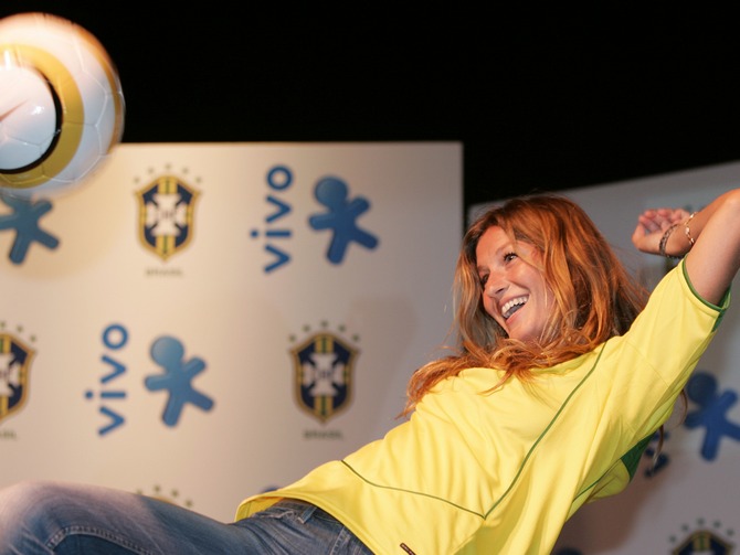 Gisele knees a soccer ball during the presentation of a new sponsor for the Brazilian national soccer team.
