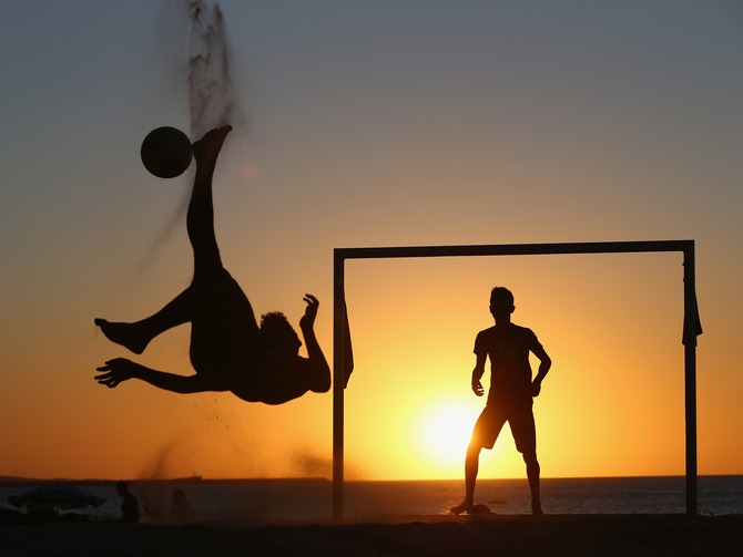 Locals play football at the Iracemar beach in Fortaleza, Brazil.